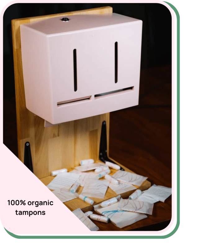 Hier wordt een tampon en maandverband dispenser laten zien van Herbox die 100% biologische menstruatieproducten uitgeeft.