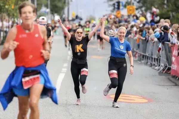 Kvinnor som löper hand i hand mot målgång i Reykjavik marathon.