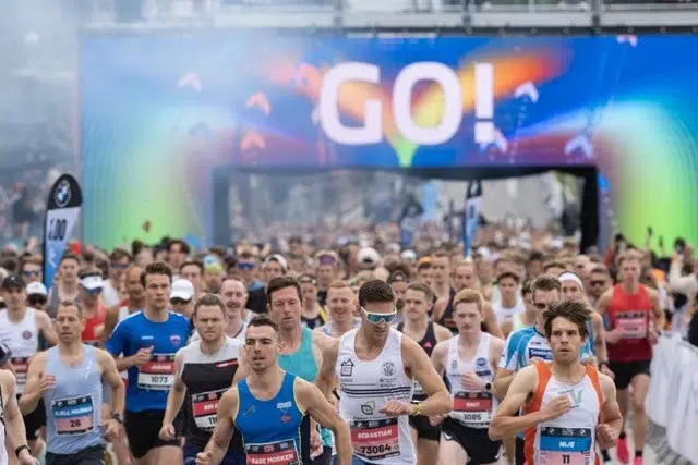 En stor grupp människor som springer Oslo maraton med träningskläder i olika färger